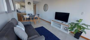 a living room with a couch and a flat screen tv at Refugio Ballenas in Puerto Madryn