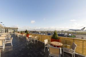 an outdoor patio with tables and chairs and an airport at Thistle London Heathrow Terminal 5 in Hillingdon