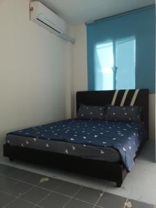 uma cama num quarto com uma parede azul em SPOT ON 90735 night Stayin em Sibu