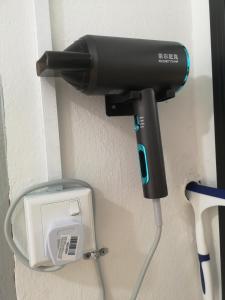 a hair dryer is plugged into a wall at SPOT ON 90735 night Stayin in Sibu