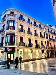 um grupo de pessoas andando em frente a um edifício em Puerta Roja 3 bedroom Luxury Apartment em Málaga