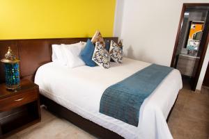 Un dormitorio con una cama grande con almohadas. en Hotel Mansión Barichara en Barichara