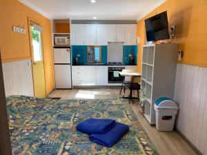 Habitación pequeña con cama y cocina en Beachcomber Caravan Park, en Mallacoota