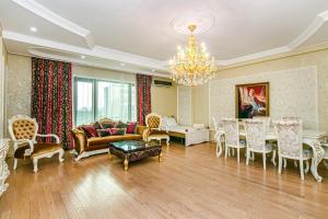 バクーにあるMc Donalds Hotel Apartment Nizami Streetのリビングルーム(シャンデリア、テーブル、椅子付)