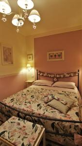 ein Schlafzimmer mit einem Bett mit geblümter Tagesdecke in der Unterkunft La casina dei cuori di nonna Miglia in Pallerone