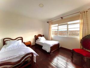1 dormitorio con 2 camas y ventana en Apartamento Colonial, en Santa Rosa de Cabal