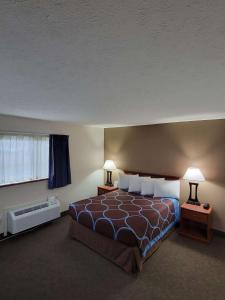 a bedroom with a bed with two lamps and a window at SureStay Plus Hotel by Best Western Grand Island in Grand Island