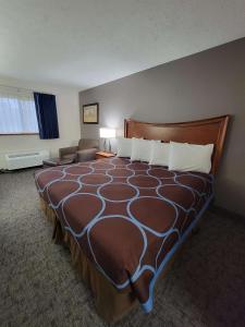 a hotel room with a large bed and a couch at SureStay Plus Hotel by Best Western Grand Island in Grand Island