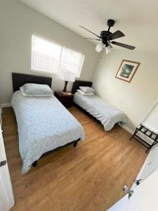 1 Schlafzimmer mit 2 Betten und einem Deckenventilator in der Unterkunft Cheerful 3 Bedroom Home mins from Clearwater Beach in Clearwater