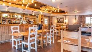 ein Restaurant mit Holztischen und -stühlen und einer Bar in der Unterkunft The Park Hotel - Sure Hotel Collection by Best Western in Diss