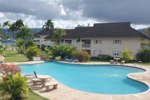 a swimming pool in front of a house at Chalet Cassie in Montego Bay