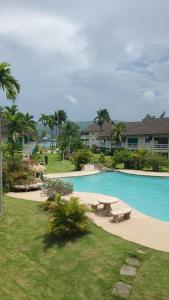 a swimming pool with a picnic table next to a house at Chalet Cassie in Montego Bay
