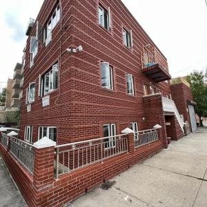 - un grand bâtiment en briques rouges avec un balcon dans l'établissement Lawn Residence, à Brooklyn