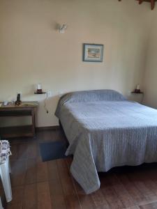 a bedroom with a large bed and a table at Pousada Do Moinho in Nazaré Paulista