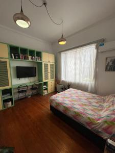 1 dormitorio con 1 cama y TV en Departamento completo amplio en Recoleta - Dos ambientes en Buenos Aires