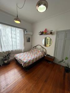 1 dormitorio con 1 cama y suelo de madera en Departamento completo amplio en Recoleta - Dos ambientes en Buenos Aires