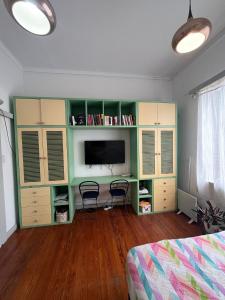 1 dormitorio con armarios verdes y blancos y TV en Departamento completo amplio en Recoleta - Dos ambientes en Buenos Aires