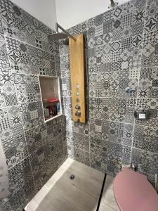 y baño con ducha y pared de azulejos. en Departamento completo amplio en Recoleta - Dos ambientes en Buenos Aires