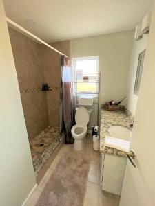 ein Bad mit einem WC, einer Dusche und einem Waschbecken in der Unterkunft Cheerful 3 Bedroom Home mins from Clearwater Beach in Clearwater