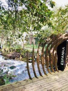 a wooden bridge over a river next to a forest at Casa 1883 in Cevide +52 photos