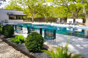 a patio with a table and chairs next to a swimming pool at Wimberley Inn & bar in Wimberley