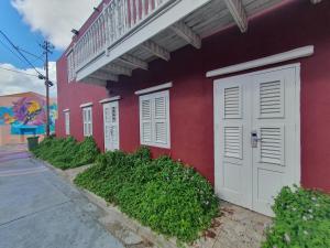 威廉斯塔德的住宿－Catherine Suites，街上有白色门的红色建筑