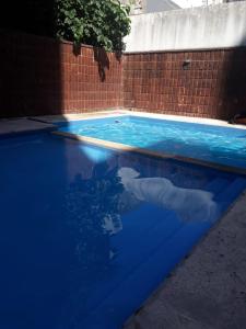 une piscine d'eau bleue et un mur en briques dans l'établissement Torres de Nuñez, à Buenos Aires