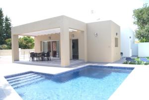 a villa with a swimming pool in front of a house at Pomera III - BTB in Beniarbeig