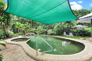 basen z zielonym parasolem w obiekcie Leumeah - A Modern Townhouse in Cairns w mieście Cairns North