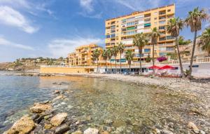 a hotel on a beach with palm trees and the water at Surf house in Benalmadena Costa