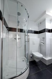 a white bathroom with a shower and a toilet at Hotel City Panorama in Hannover