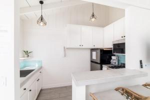 a kitchen with white cabinets and a counter top at Pacific Villas in Oceanside