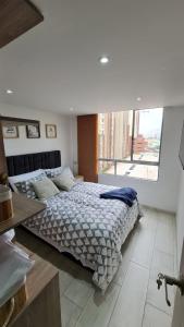 um quarto com uma cama grande e uma janela grande em Apartamento imperdible en Bogotá norte em Bogotá