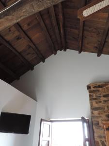 een kamer met houten plafonds en een raam bij El Rincón Maragato in Castrillo De Los Polvazares