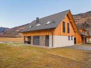 una casa con techo de gambrel con garaje en Mountain Chalet Krek Wak Wou en Sankt Lorenzen ob Murau