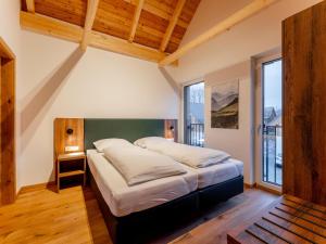 1 dormitorio con 1 cama grande en una habitación con ventanas en Mountain Chalet Krek Wak Wou, en Sankt Lorenzen ob Murau