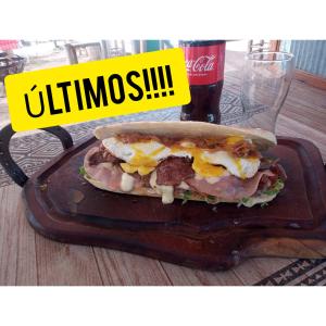 a sandwich on a cutting board with a sign that reads unintentional at DORMIS P/2 in Ciudad Lujan de Cuyo