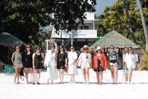 In Dai Aquasports and Beach Resort في جزيرة بانتايان: مجموعة نساء واقفات على الشاطئ
