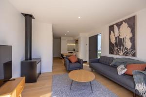 a living room with a couch and a table at Alpine Junction Townhouse Apartments, Lodge & Hotel in Wanaka