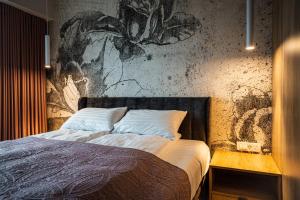 ポズナンにあるFillhus Apartmentsのベッドルーム1室(壁に絵画が描かれたベッド1台付)