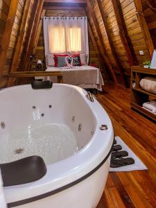 a bath tub in a room with a bedroom at Morada do Corujão - Sossego das Águas in Praia Grande