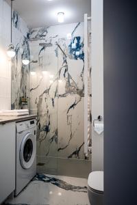 a bathroom with a shower with a washing machine at Fillhus Apartments in Poznań