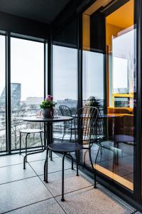 una mesa y sillas en una habitación con ventanas en Fillhus Apartments en Poznan