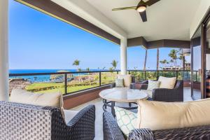 d'une terrasse avec des chaises et une table et une vue sur l'océan. dans l'établissement Mauna Lani Point, à Waikoloa