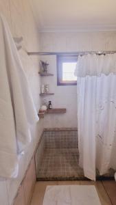 a bathroom with a shower with a white shower curtain at TU CASA Rent House in Esperanza
