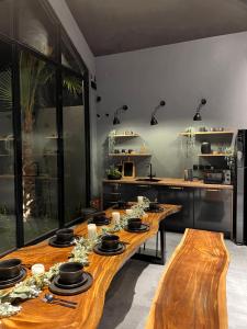 a kitchen with two wooden tables with dishes on them at شاليه كوتج in Buraydah