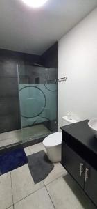 a bathroom with a toilet and a glass shower at De León Huehuetenango in Las Victorias