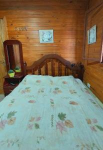 una camera da letto con un letto con copriletto floreale di Hostel Raíces Salta a Salta
