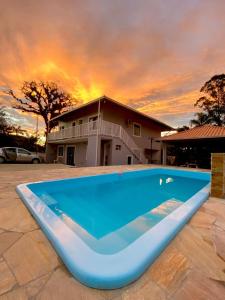 a large blue swimming pool in front of a house at Pequeno apartamento em chacara próximo às praias com internet in São Francisco do Sul