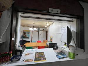 an office with a desk with a table and a room at HOSTEL OE in Yoshinogawa
